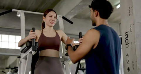 Young Asian couple preparing gym exercise together, woman holds handles on knee Stock Footage 338043146