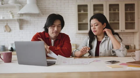 Young Asian couple reviewing documents, upset about family business debts Stock Footage 327866295
