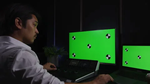 Young Asian editor color grading on our professional panel Stock Footage 264222262