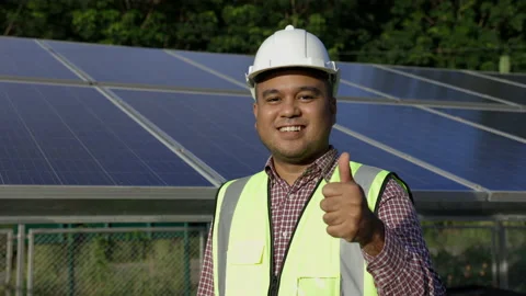 Young asian electrical engineer standing in front of Solar cell panels farm. He  Stock Footage 158902549