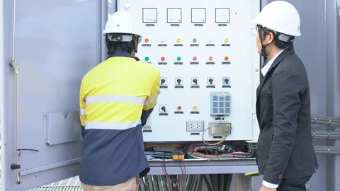 Young Asian engineer checking electrical control cabinet with executive engineer 스톡 동영상 129034735