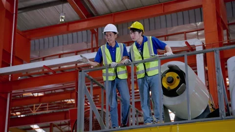 Young Asian engineer explains to a foreman about a factory action plan. Stock Footage 175767885