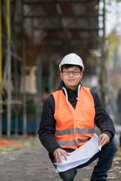 Young Asian engineer at work on construction site Stock Photos