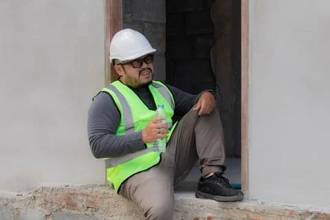 Young Asian engineering worker overweight employee foreman tired sitting on.. Stock Photos