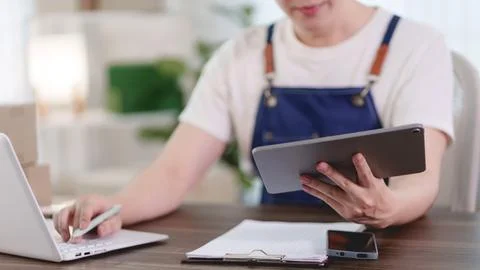 Young Asian entrepreneur using tablet and laptop for online merchant operat.. Stock-Fotos