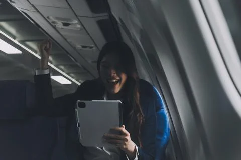 Young Asian executive excels in first class, multitasking with digital tabl.. Stock Photos