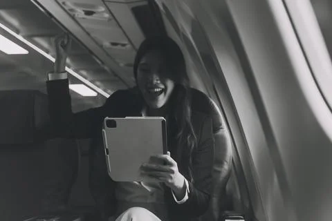 Young Asian executive excels in first class, multitasking with digital tabl.. Stock Photos