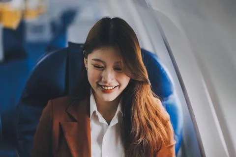.Young Asian executive excels in first class, multitasking with digital tab.. Stock Photos