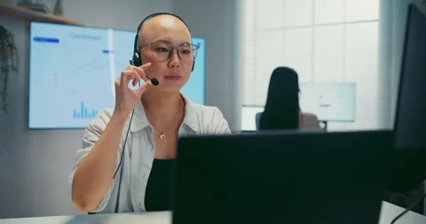 Young Asian female agent talking on phone headset consulting client online. Stock Footage 340814833
