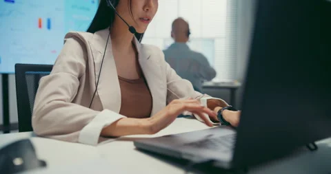 Young Asian female agent talking on phone headset consulting client online. Stock Footage 340815281
