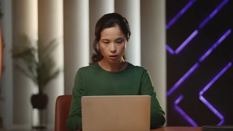 Young Asian female author develops ideas while typing on laptop, freelance Stock Footage 343663779