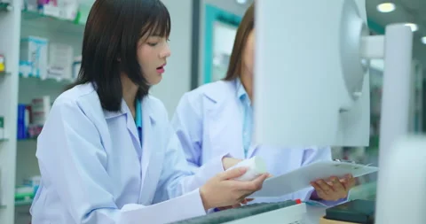 Young asian female pharmacist using computer in pharmacy shop. Stock-Footage 250382020
