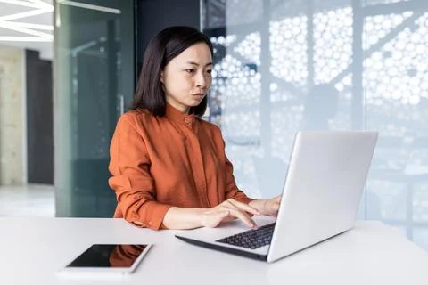 Young Asian female programmer, developer, tester is focused and serious sitting Foto stock