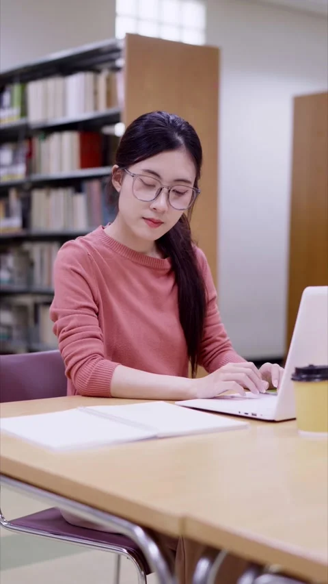Young Asian female student using laptop computer for research study assignm.. Stock Footage 335003412