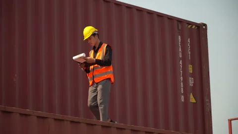 Young asian foreman checking list on clipboard talking on the walkie-talkie c Stock Footage 157716455