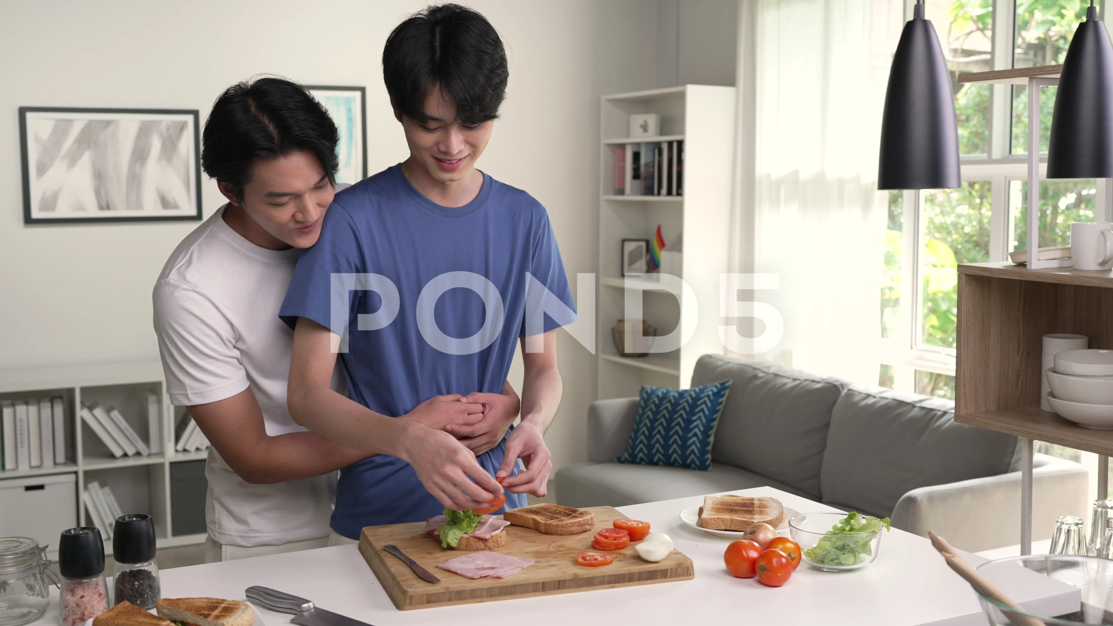 Young Asian gay couple looking happy having fun while spending time and  cooking