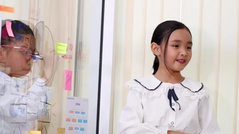 Young Asian Girl Presenting Data on Glass Board in Classroom Stock Footage 334773219