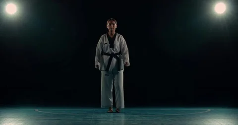Young asian girl trains martial arts taekwondo, performs kicks, slow motion Stock Footage
