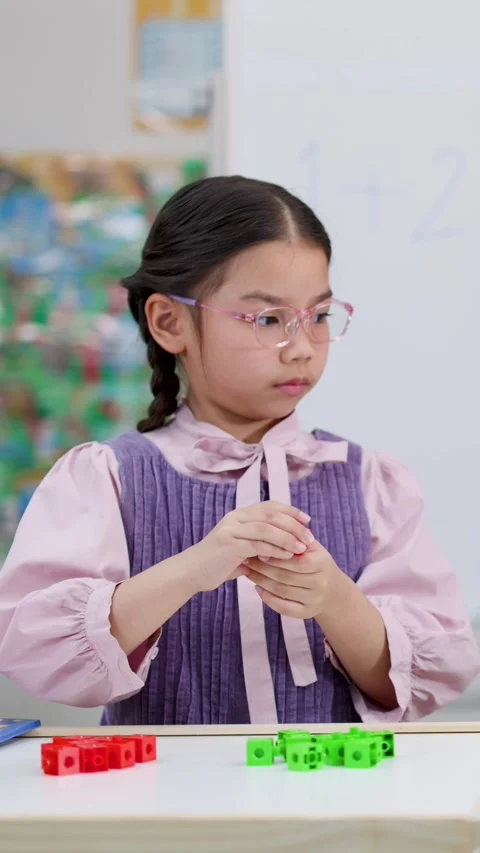 Young Asian Girl Using Math Cubes for Arithmetic in Classroom Stock Footage 327770893