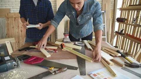 Young Asian group man worker measuring wood plank for build diy wood furniture Stock Footage 124103606