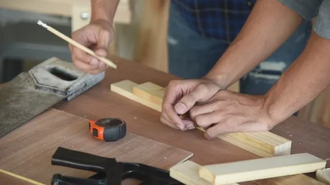 Young Asian group man worker preparing to cut wood plank for build diy furniture Stock Footage 124183866