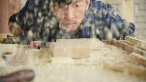 Young Asian group man worker blow sawdust Stock Footage 124886986