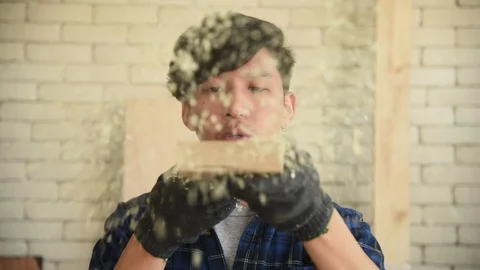 Young Asian group man worker blow sawdust Stock Footage 124887027