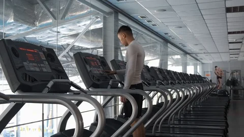 Young Asian guy is running on a treadmill in a gym. Stock Footage 114290920