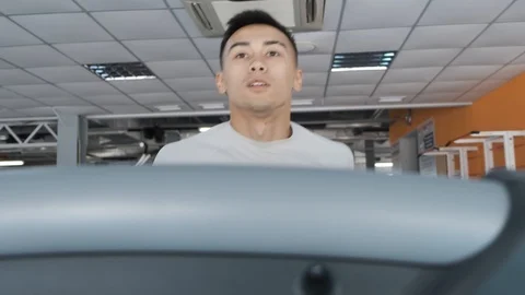 Young Asian guy is running on a treadmill in a gym. Stock Footage 114290972