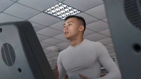 Young Asian guy is running on a treadmill in a gym. Stock Footage 114291081