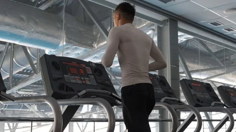 Young Asian guy is running on a treadmill in a gym. Stock Footage 114291105