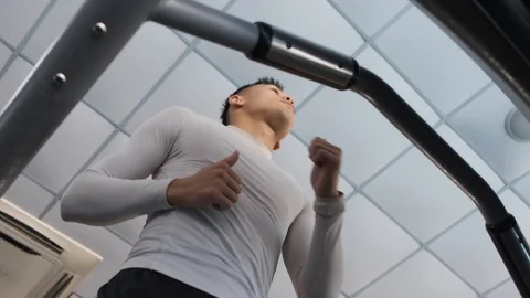 Young Asian guy is running on a treadmill in a gym. Stock Footage 114291335