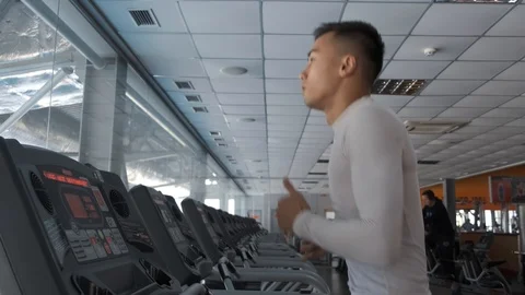 Young Asian guy is running on a treadmill in a gym. Stock Footage 114291347