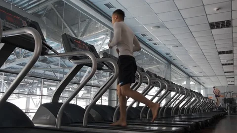 Young Asian guy is running on a treadmill in a gym. Stock Footage 114291372