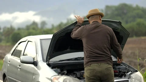 Young asian has broken down car. He open hood and check the engine. He feeling. Stock Footage 158904416