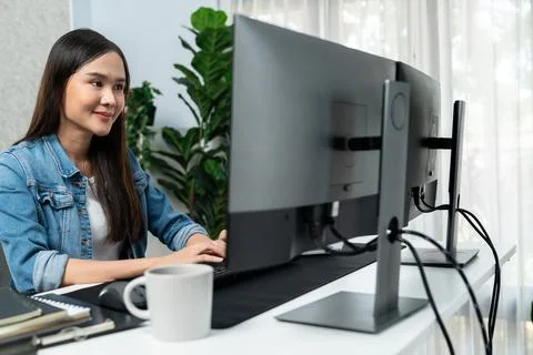 Young Asian in IT creating with typing online information on pc. Stratagem. Foto stock