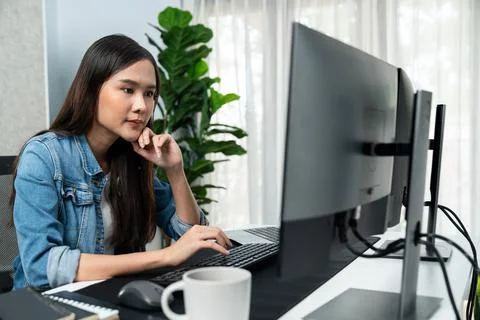 Young Asian in IT creating with typing online information on pc. Stratagem. Stock-Fotos
