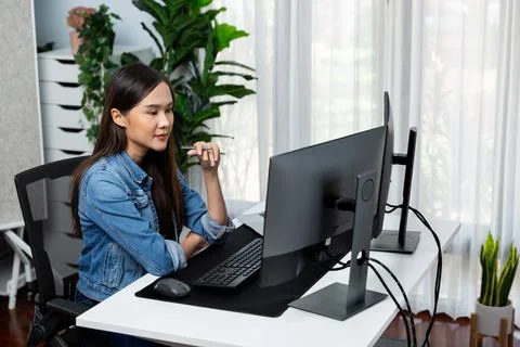 Young Asian in IT developer looking online information on pc to pose. Stratagem. Foto stock