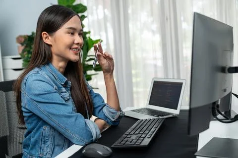 Young Asian in IT developer looking online information on pc to pose. Stratagem. Stock Photos