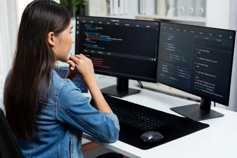 Young Asian in IT developer looking online information on pc to pose. Stratagem. Stockfoto's