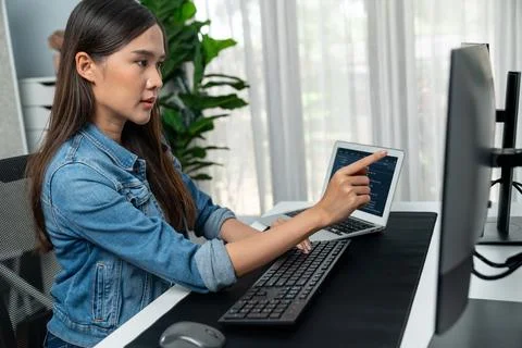 Young Asian in IT developer pointing online information on pc. Stratagem. Stock Photos