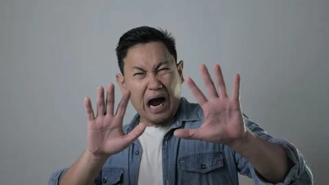 Young  Asian man afraid expression with hands raised up, covering Stock Footage 143517818