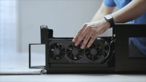A young Asian man assembling an external GPU device_WFH Day 37 Stock Footage 129726094