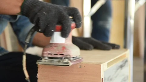 Young Asian man carpenter worker use grinder machine to grind wood plank Stock Footage 124885716