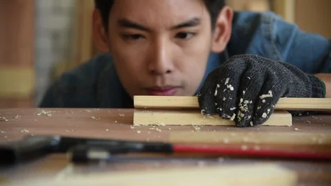 Young Asian man carpenter worker blow sawdust Stock Footage 124885777