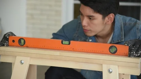 Young Asian man carpenter worker measuring water level from wood plank Stock Footage 124901191