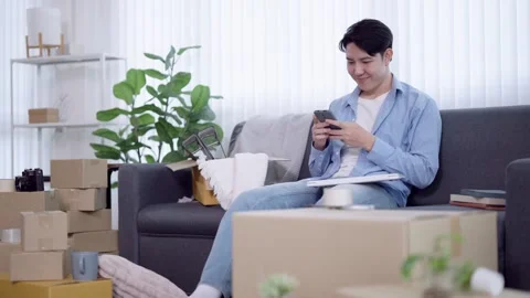 Young Asian man checking smartphone while managing online business orders s.. Stock Footage 341588378