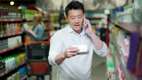 Young Asian man chooses Personal care hygiene products, in a supermarket store.  Stock Footage 199846088
