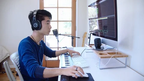Young Asian Man Composes Music in Home Recording Studio Stock Footage 112684384