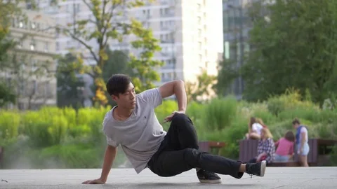 Young Asian Man dancing Breakdance in the park Stock Footage